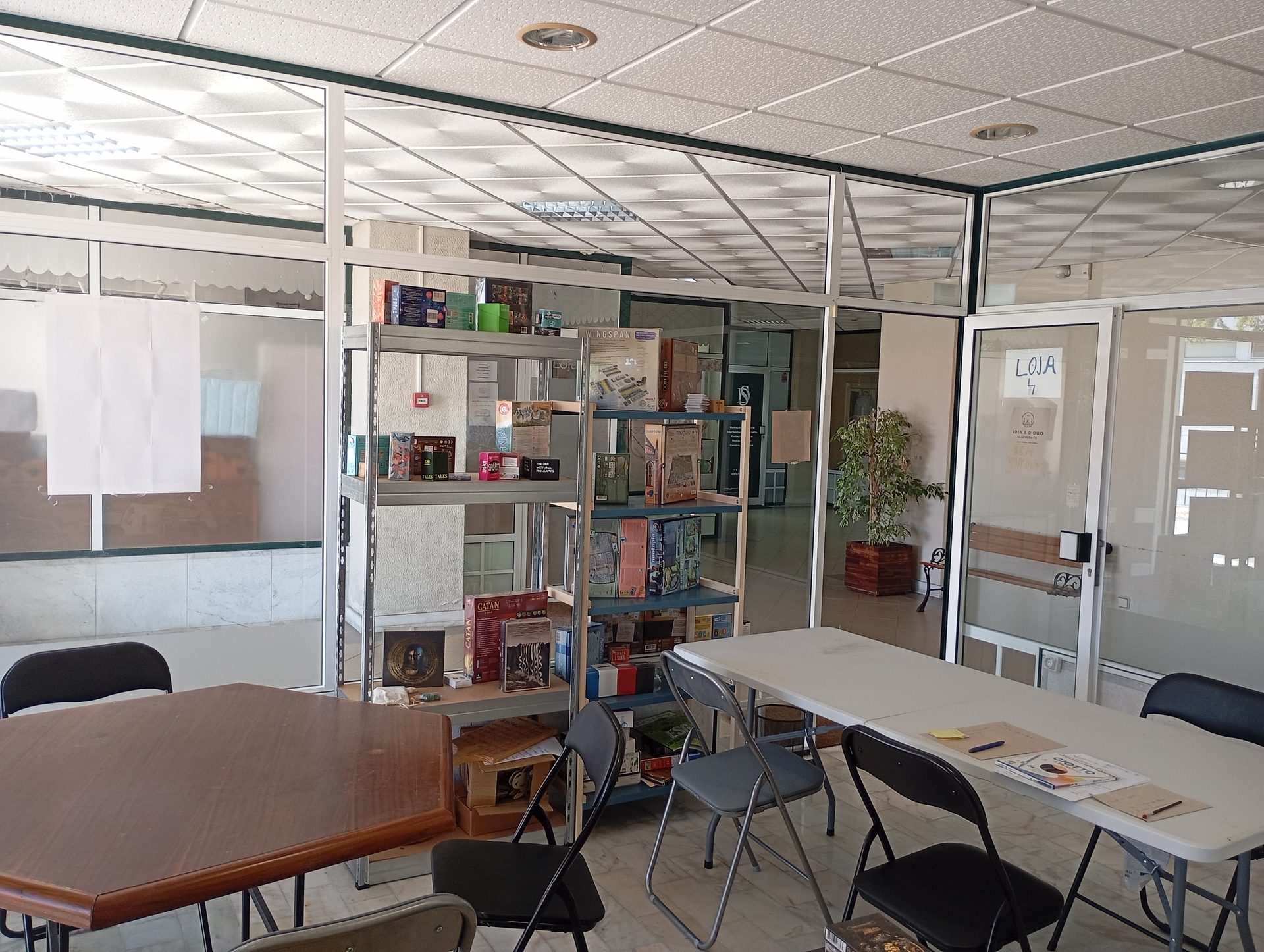 Interior do espaço com mesas de trabalho e estantes